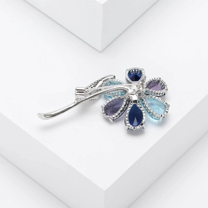 Detailed macro view of colorful zircon flower brooch with polished silver metal petals