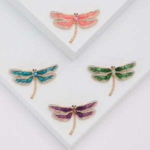 Détails de quatre broches libellules colorées en émail serties de cristaux brillants