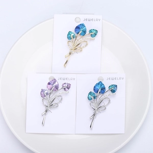 Detailed macro view of heart crystal bouquet brooches in three elegant color variants