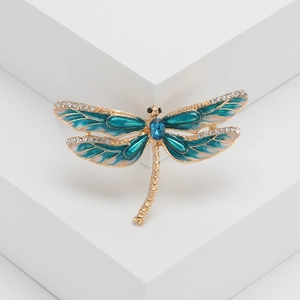 Vue détaillée de la broche libellule avec ailes en émail bleu et strass scintillants