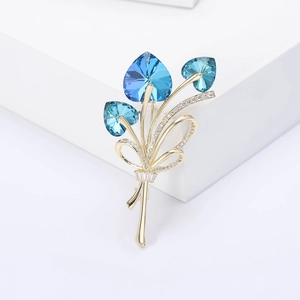 Detailed macro of crystal bouquet brooch with blue heart gems and micro-pave rhinestones