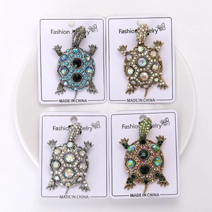 Gros plan de broches tortue vintage en quatre couleurs avec strass étincelants