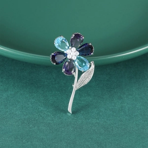 Exquisite floral brooch with blue and purple gemstones, pearls, and silver leaves
