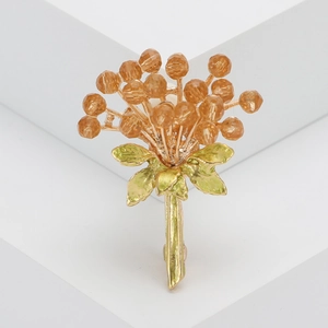 Élégante broche bouquet de fleurs dorée avec strass champagne et feuilles émaillées