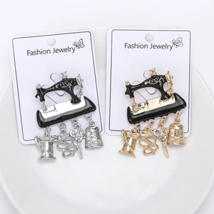 Detail view of gold and silver vintage sewing machine brooches with tool charms