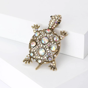 Vue détaillée d'une broche tortue sertie de strass colorés sur une base en bronze