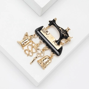 Detailed close-up of retro sewing machine brooch with hanging scissors and tape measure