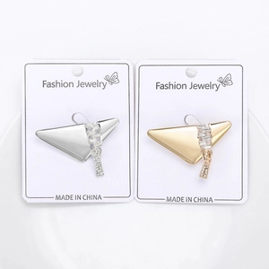 Detail of silver and gold triangle zipper brooches with crystal rhinestones on display card