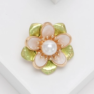 Detalle de un broche de camelia con pétalos blancos y hojas de esmalte verde refinado