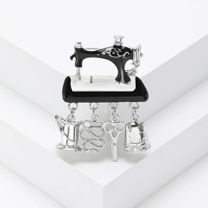 Vintage sewing machine brooch in black enamel with silver alloy charms and sewing tools