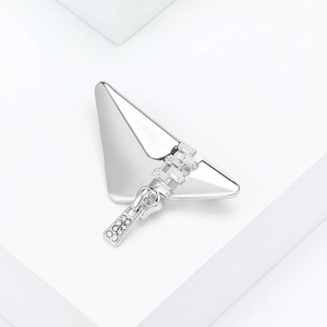 Macro shot of silver butterfly brooch with zipper element and embedded crystals