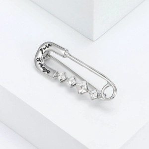 Détail macro d'une broche épingle argentée avec gravure Love you et strass brillants