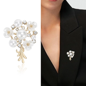 Elegante spilla a bouquet di perle con petali di smalto bianco su blazer nero