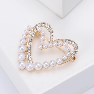 Dettaglio ravvicinato di una spilla a cuore con perle eleganti e strass scintillanti