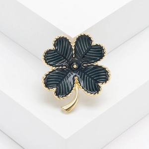 Élégante broche trèfle à quatre feuilles dorée avec émail vert foncé et bordure torsadée