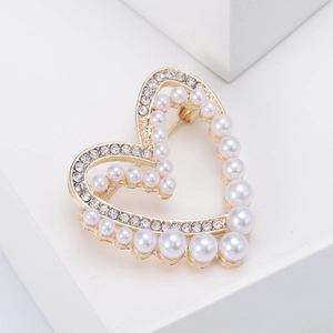 Elegante spilla a cuore dorata con perle bianche e cristalli su una base minimalista