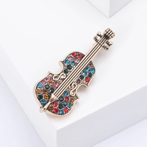 Detailed macro view of retro violin brooch with vibrant colorful rhinestones and gold finish