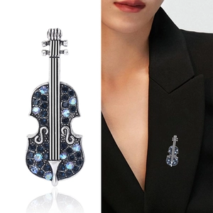 Vintage violin brooch with blue rhinestones and silver finish on a suit jacket