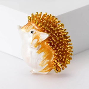 Detailed view of hedgehog brooch with gold plating and orange enamel gradient drip oil finish