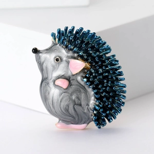 Macro detail of enamel hedgehog brooch showing blue spines and fine metallic textures