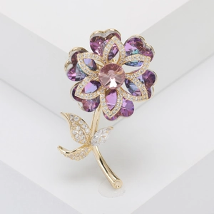 Macro shot of elegant purple crystal flower brooch with gold plating and zircons