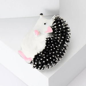 Detailed macro shot of creative enamel hedgehog brooch with silver-tipped black spikes