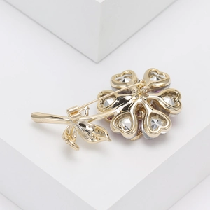 Detailed back view of a gold flower brooch showing the secure pin fastener and hollow design
