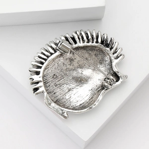 Vintage silver hedgehog brooch with enamel detail and secure pin clasp on white block