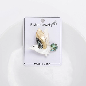 Detailed view of a bird brooch made of natural mother-of-pearl and abalone shell inlays