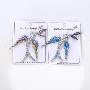 Detailed macro view of two swallow brooches with colorful enamel and sparkling rhinestones