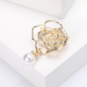 Detaillierte Nahaufnahme einer goldenen Kamelien-Brosche mit elegantem Perlenanhänger