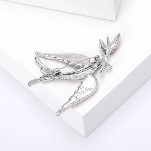 Detailed back view of silver swallow brooch showing texture and secure safety pin clasp