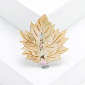 Macro detail of maple leaf brooch featuring natural mother of pearl and abalone shell inlay