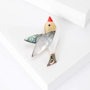 Broche oiseau élégante avec incrustation de nacre naturelle et détail de bec rouge