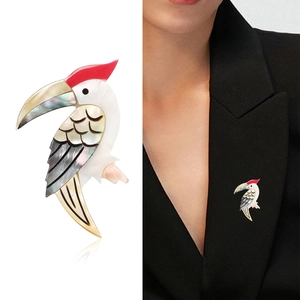 Eleganter Vogel-Anstecknadel mit buntem Perlmutt auf Modell und weißem Hintergrund