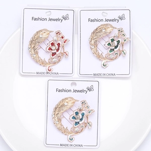 Vue détaillée de trois broches fleurs plumes émaillées avec strass sur cartes de mode