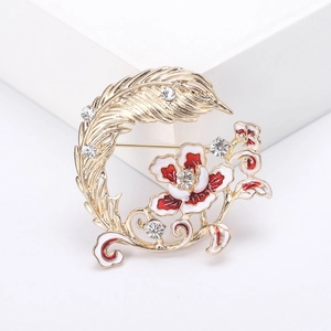 Élégante broche fleur et plume plaquée or avec émail rouge et strass brillants