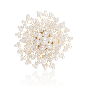 Vue détaillée d'une broche en perles élégante avec fils dorés et perles blanches chic