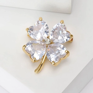 Detailed macro view of crystal four-leaf clover brooch with gold-plated alloy base