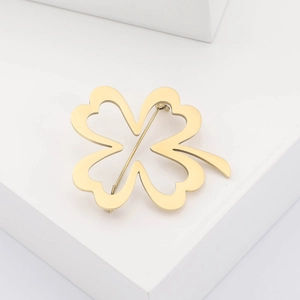 Detailed close-up of a minimalist hollow gold-plated four-leaf clover brooch