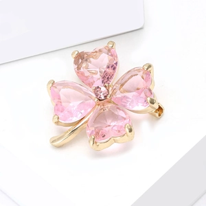 Detail of pink crystal clover brooch with heart-shaped petals in gold-plated claw setting