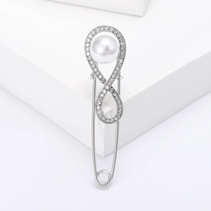 Elegant infinity safety pin brooch with silver metal, rhinestones and white pearl detail