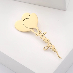 Macro view of golden heart brooch featuring an elegant I love you script design