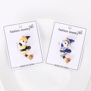 Detail of wizard cat enamel pins in yellow and blue, displayed on a jewelry card