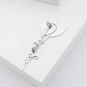 Detailed back view of silver heart brooch with secure pin clasp on white steps