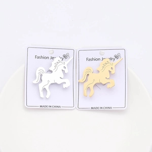 Detail of gold and silver unicorn brooches with brushed finish on fashion jewelry cards