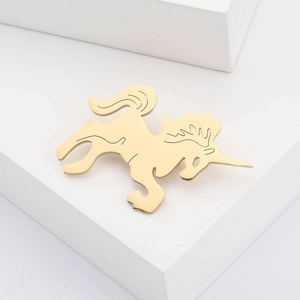 Polished gold unicorn brooch minimalist animal pin on matte white platform