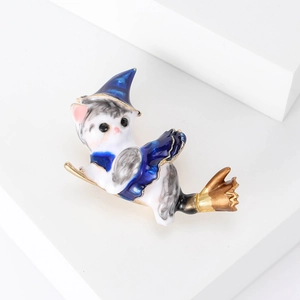 Cute enamel magic cat brooch with wizard hat and golden broom on white pedestal