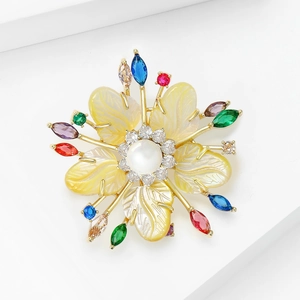 Broche florale élégante avec zircons colorés et accents de perles sur fond blanc