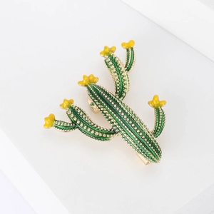 Broche cactus créative en émail avec fleurs jaunes et accents dorés sur support blanc